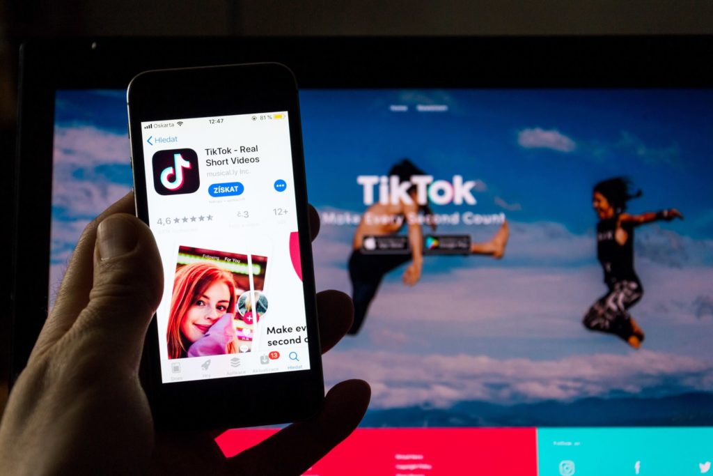 Person holding a mobile phone with the TIkTok app loaded
